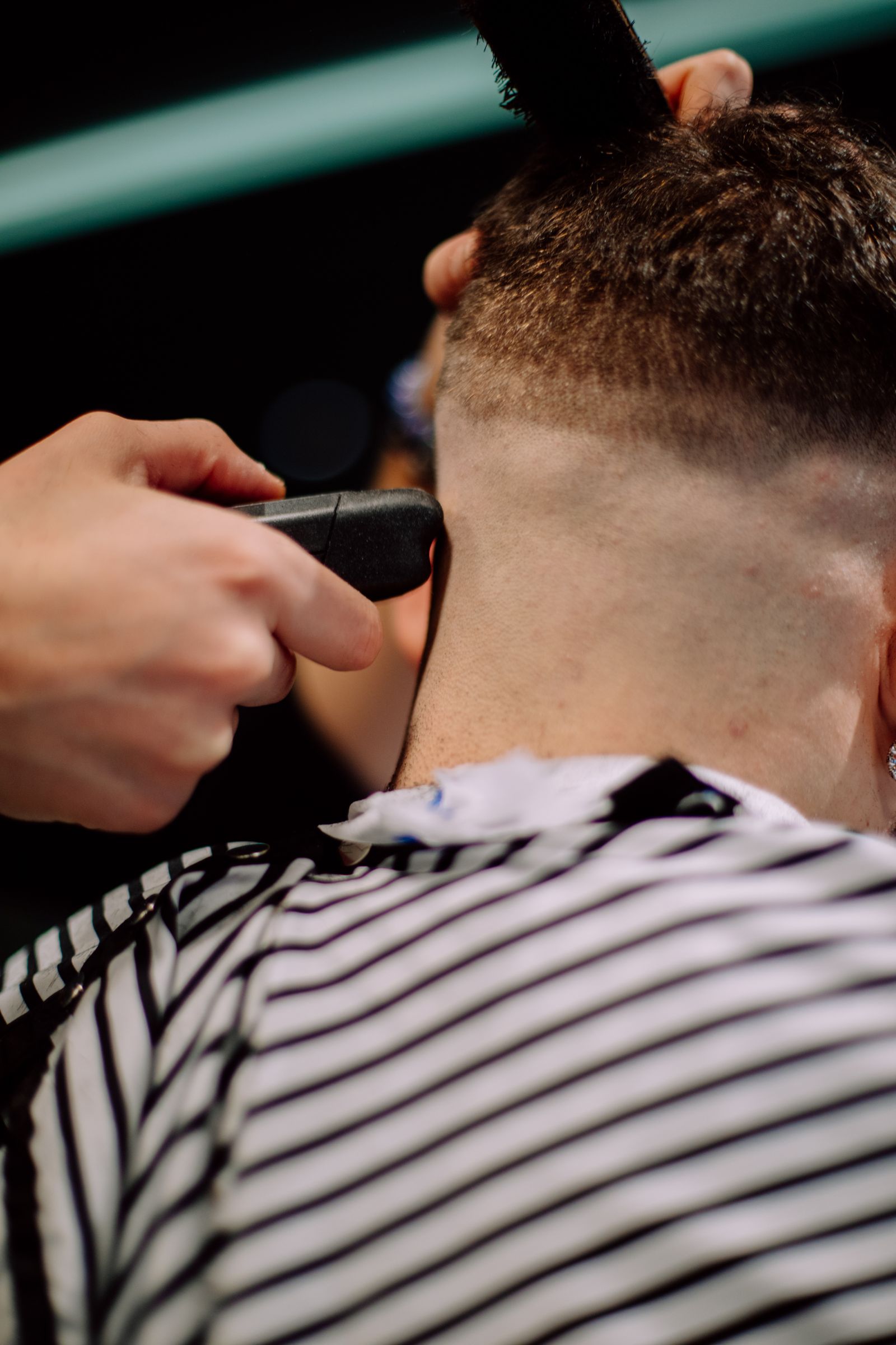A barber finishing a precise skin fade